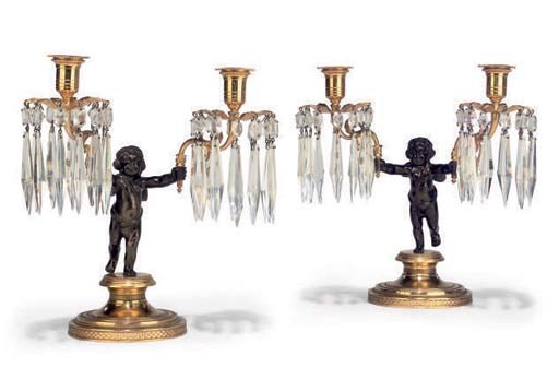 A PAIR OF GILT AND PATINATED METAL TWIN-LIGHT CANDELABRA