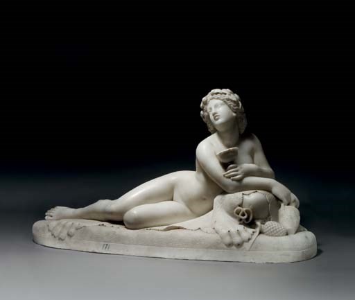A CARVED MARBLE FIGURE OF A RECLINING BACCHANTE