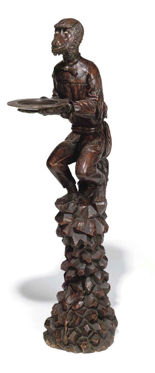 A BLACK FOREST CARVED AND STAINED LIMEWOOD FIGURAL DUMB WAITER