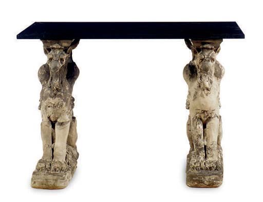 A CARVED STONE TRESTLE TABLE WITH BLACK GRANITE TOP,
