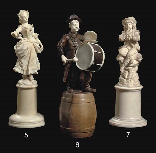 A GERMAN CARVED IVORY AND FRUITWOOD FIGURE OF A BANDSMAN