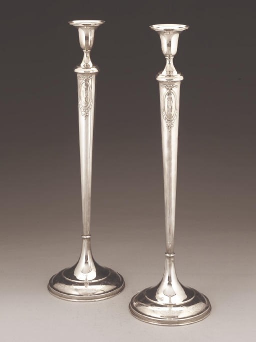 AN UNUSUALLY TALL PAIR OF AMERICAN METALWARE CANDLESTICKS,
