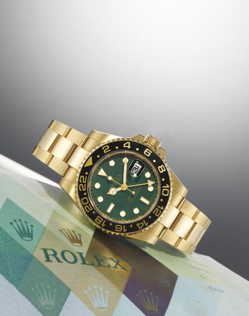 ROLEX. AN 18K GOLD AUTOMATIC TWO TIME ZONE WRISTWATCH WITH BRACELET, CENTRE SECONDS, DATE AND GREEN DIAL