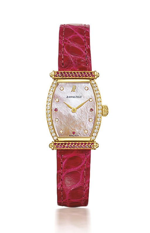 AUDEMARS PIGUET. A LADY'S 18K GOLD, DIAMOND AND RUBY-SET TONNEAU-SHAPED WRISTWATCH WITH MOTHER-OF-PEARL DIAL
