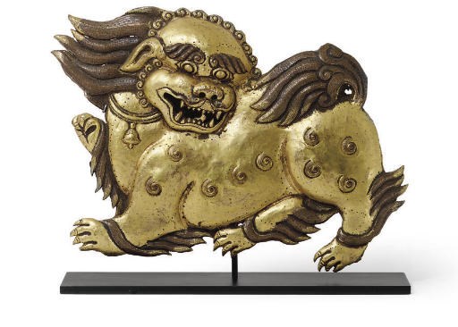 A gilt copper repousse lion plaque