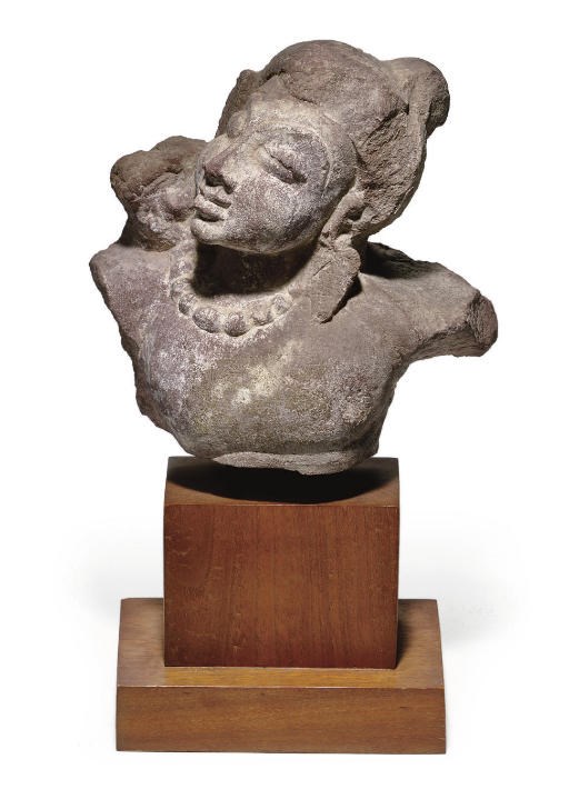 A small red sandstone bust of an attendant