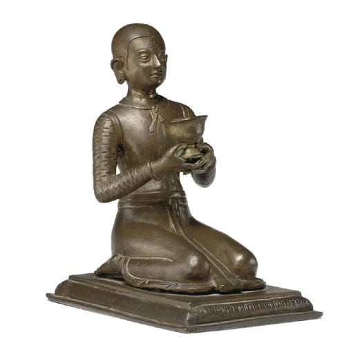 A copper figure of a kneeling donor