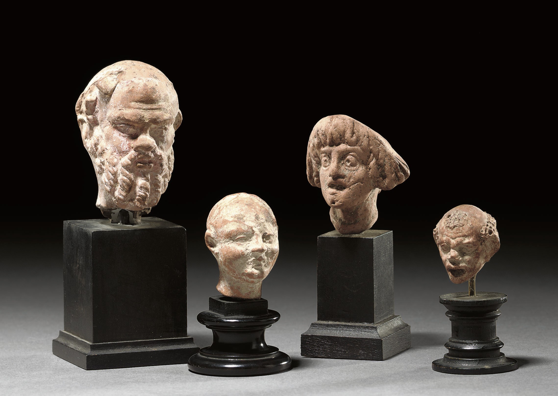 A GROUP OF FOUR GREEK TERRACOTTA HEADS
