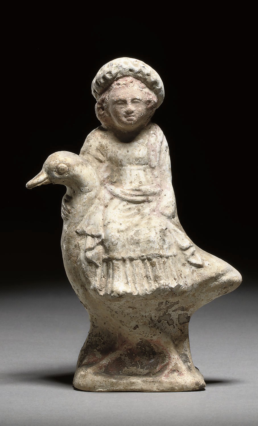 A GREEK TERRACOTTA STATUETTE OF A CHILD RIDING ON A GOOSE