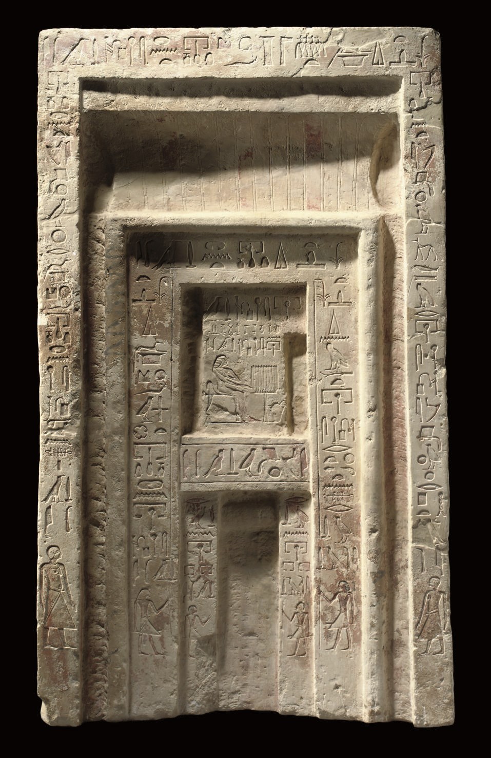 AN EGYPTIAN PAINTED LIMESTONE FALSE DOOR OF THE INSPECTOR OF THE SCRIBES OF THE TREASURY, DJATY