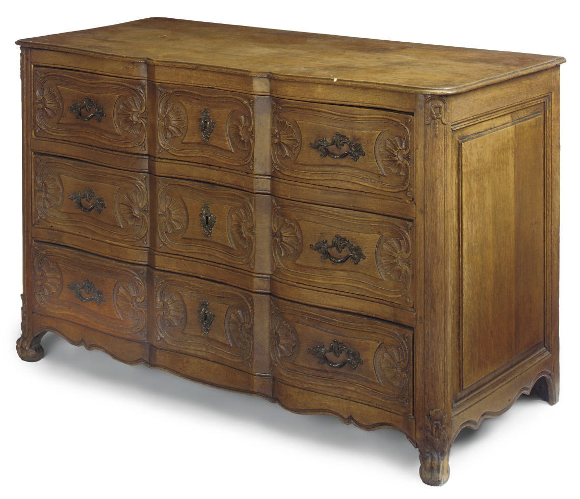 A CARVED OAK SERPENTINE COMMODE