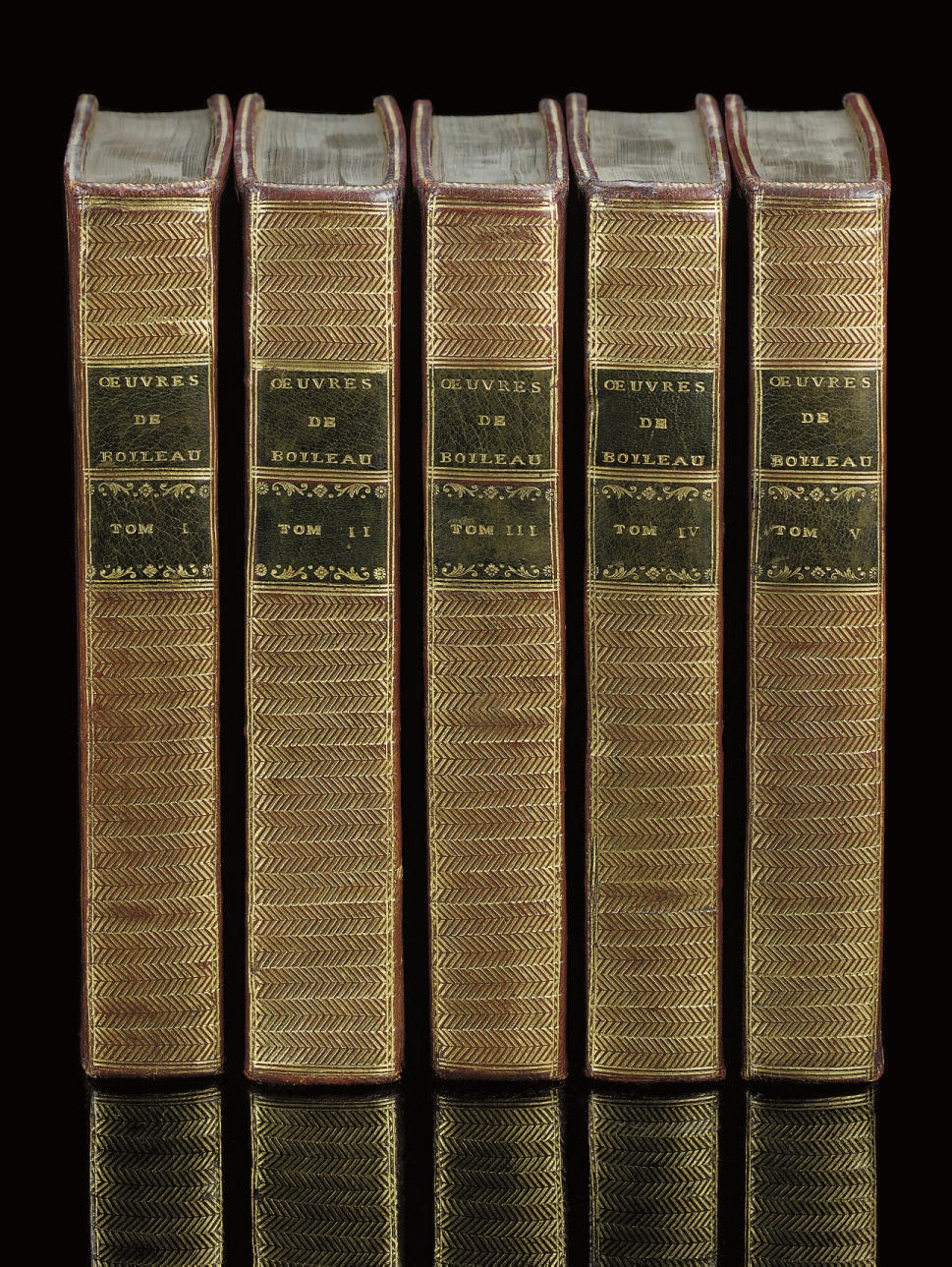 BOILEAU-DESPREAUX, Nicolas (1636-1711). Oeuvres, edited by Brossette and Saint-Marc. Amsterdam: D.J. Changuion, 1771. Titles printed in red and black with differing engraved vignette, engraved frontispiece in volume I and 8 plates in volume II, half-titles (without the frontispieces in vol.II-V called for by Cohen-de Ricci). Contemporary French red morocco, triple line border round sides, flat spines gilt to a zigzag chevron pattern and with green morocco lettering and numbering pieces, inner dentelles, gilt edges. Cohen-de Ricci 170 (calling for only 6 plates).	 (5)