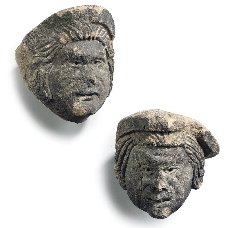 A PAIR OF ENGLISH CARVED GREY STONE HEADS