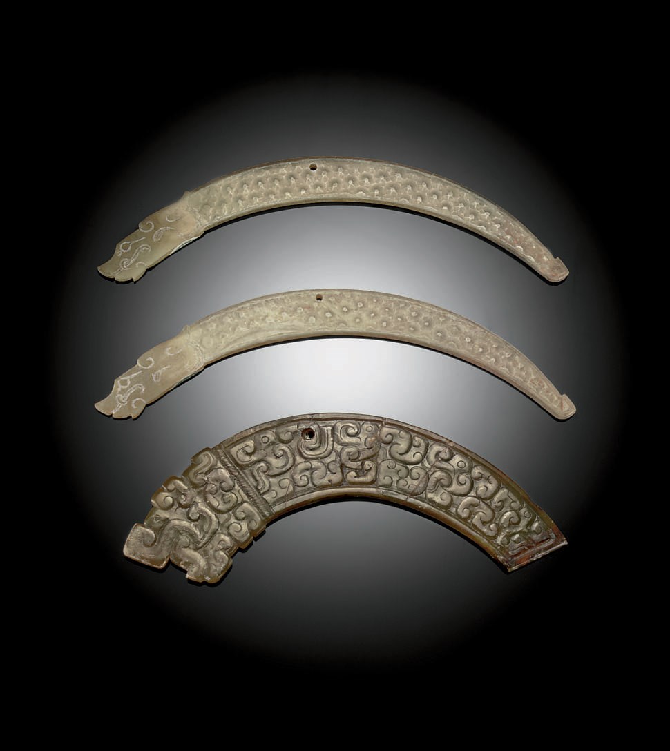 A PAIR OF GREYISH-GREEN JADE CURVED DRAGON PENDANTS