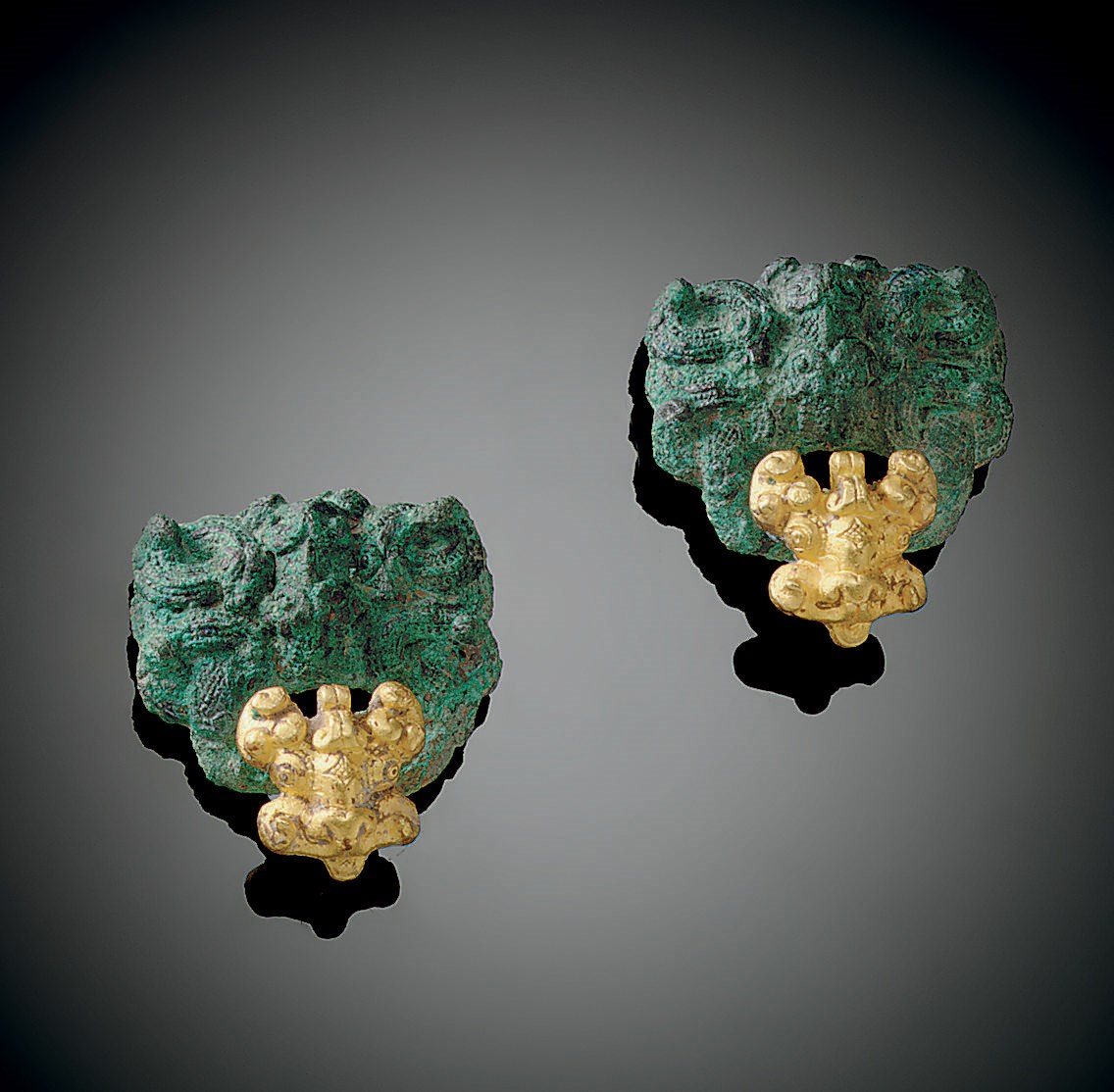 A PAIR OF GOLD FOIL-DECORATED BRONZE FITTINGS