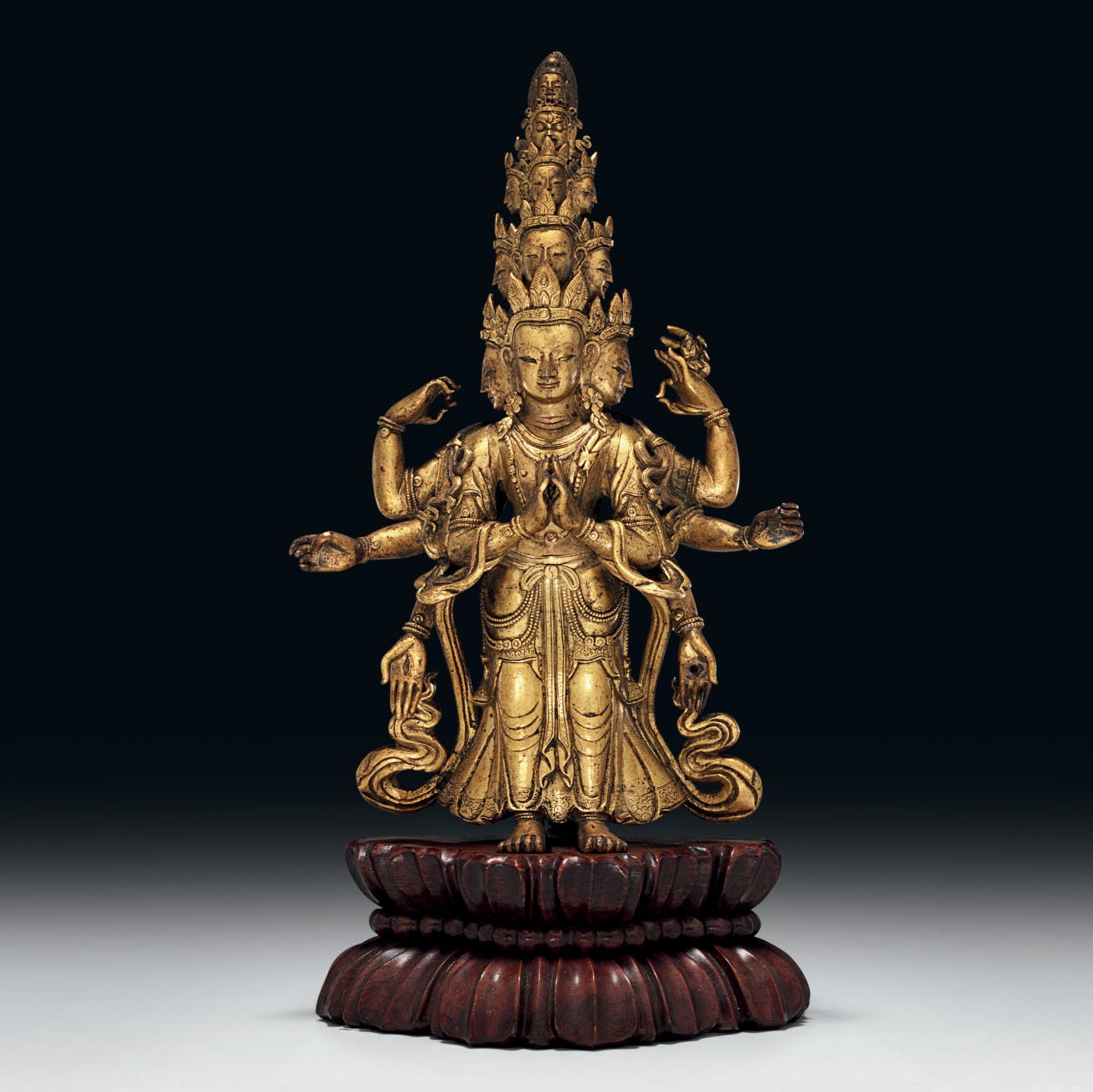 A SMALL GILT-BRONZE FIGURE OF AN ELEVEN-HEADED AVALOKITESVARA