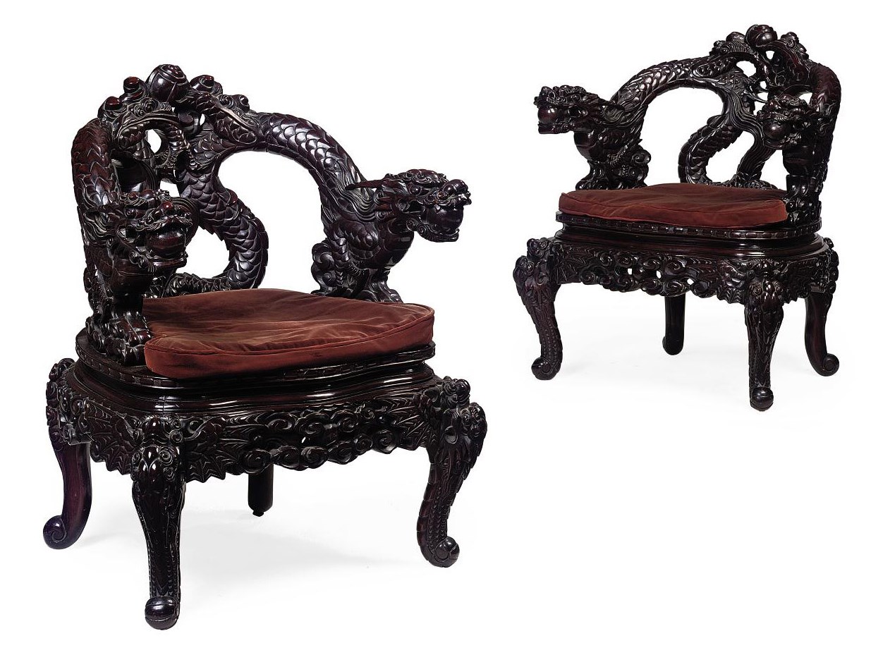 A PAIR OF SOUTH EAST ASIAN CARVED HARDWOOD OPEN ARMCHAIRS