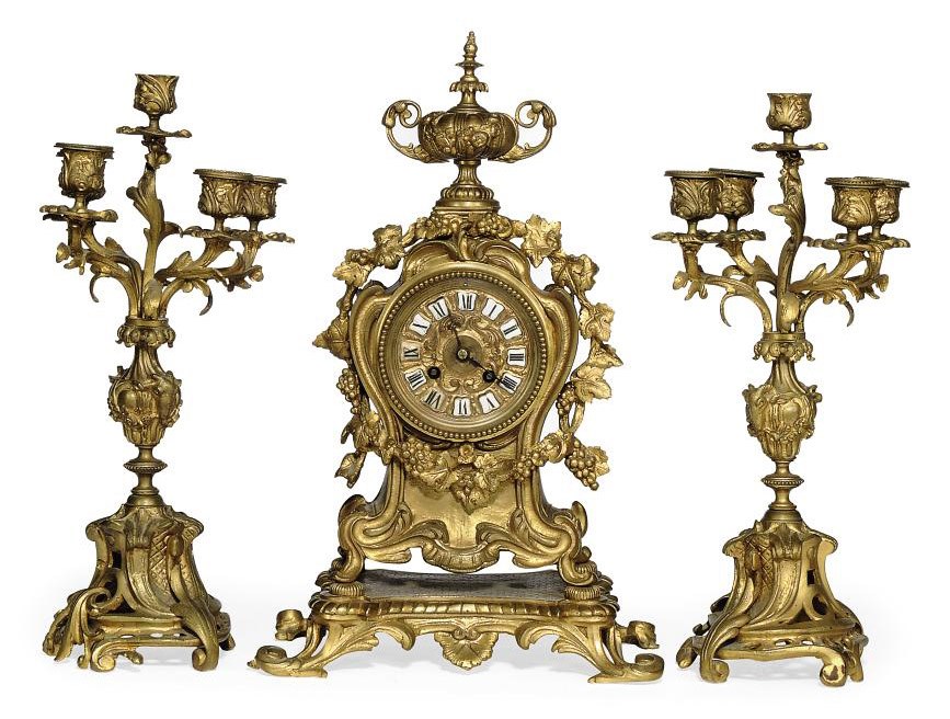 A FRENCH BRONZE STRIKING MANTEL CLOCK AND GARNITURE