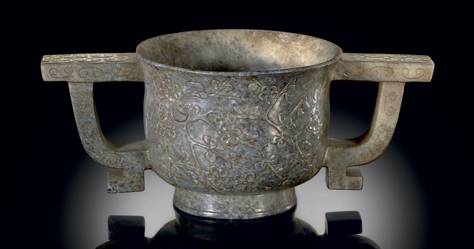 AN UNUSUAL 'CHICKEN BONE' JADE TWO-HANDLED CUP