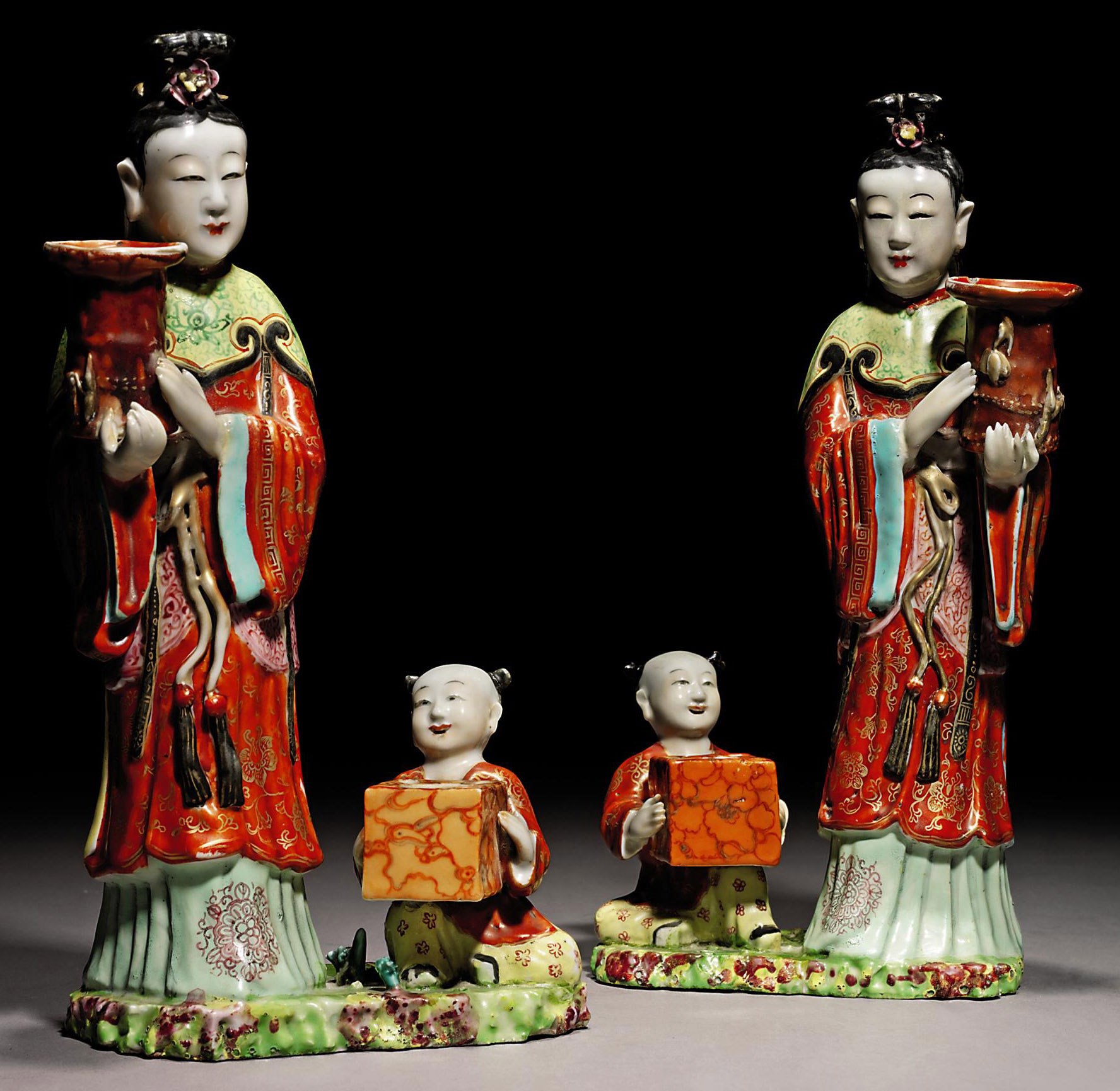 A PAIR OF UNUSUAL FAMILLE ROSE 'LADY AND BOY' CANDLE-HOLDERS