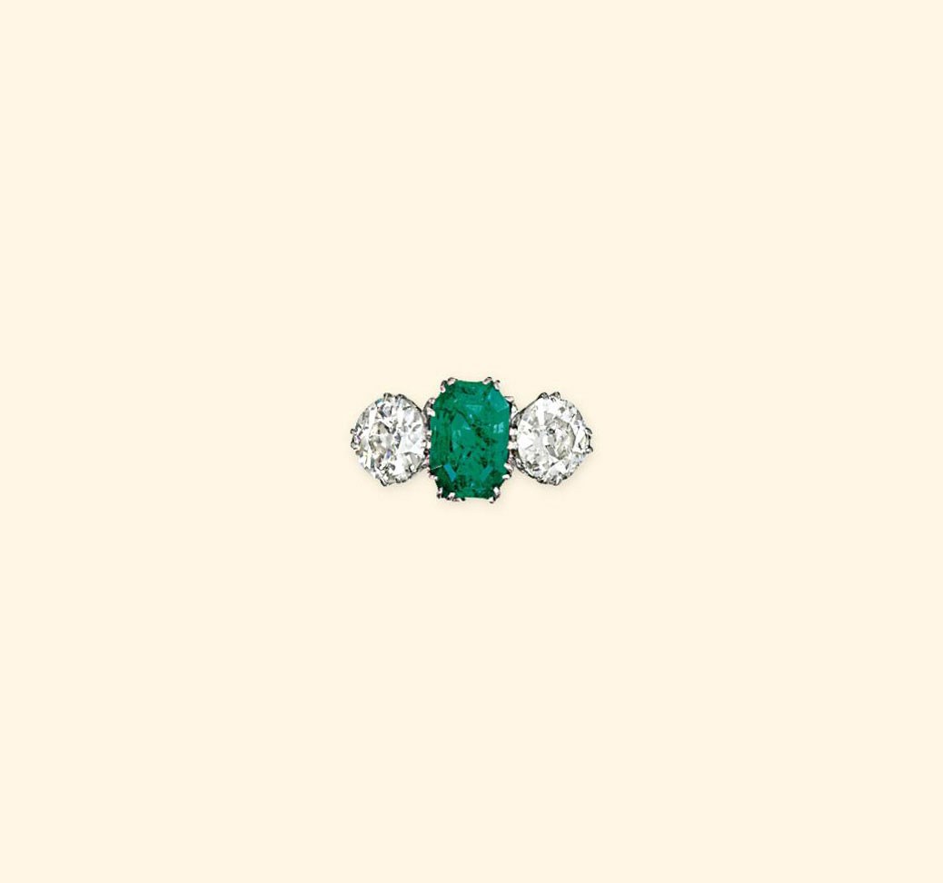 AN EARLY 20TH CENTURY EMERALD AND DIAMOND THREE-STONE RING