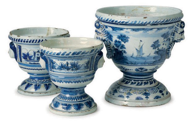 AN ASSEMBLED CONTINENTAL DELFT GARNITURE OF THREE BLUE AND WHITE LANDSCAPE-DECORATED KRATER-FORM FLOWER POTS,
