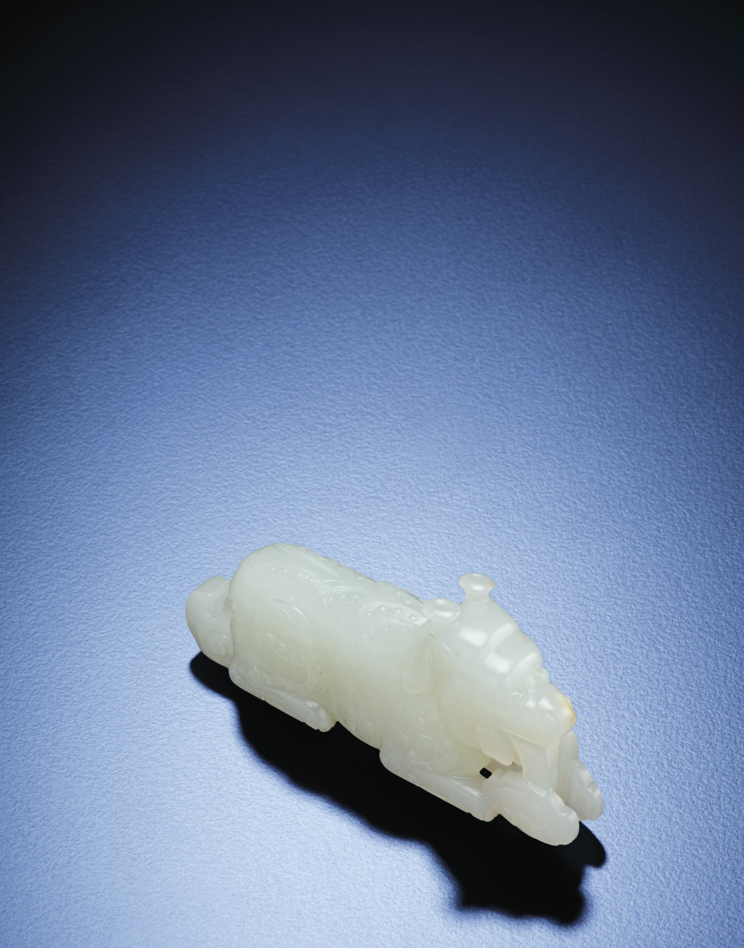 A FINELY CARVED WHITE JADE RECUMBENT QILIN