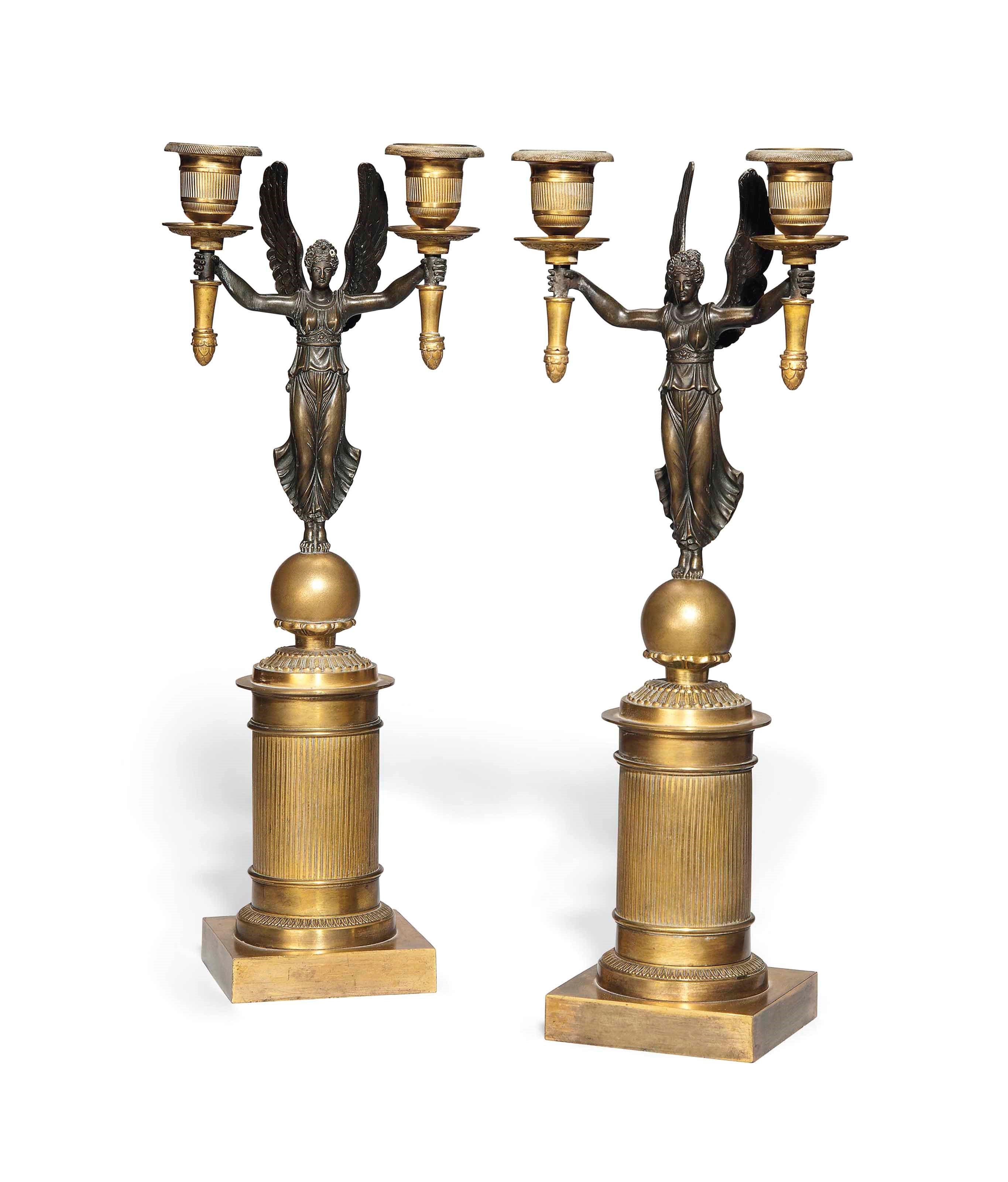 A PAIR OF GILT AND PATINATED BRONZE FIGURAL TWIN-LIGHT CANDELABRA