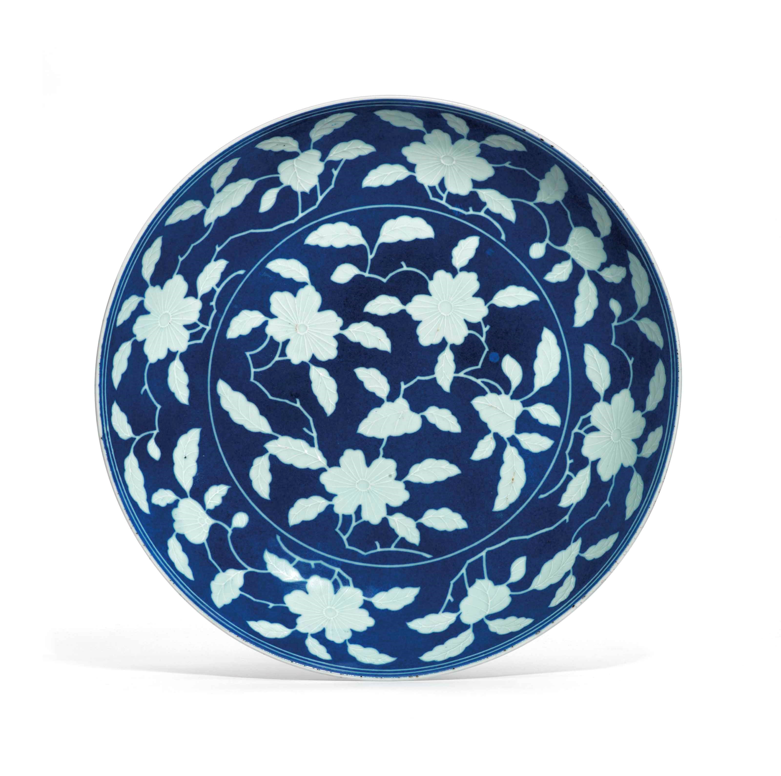 A RARE RESERVE-DECORATED BLUE-GROUND DISH