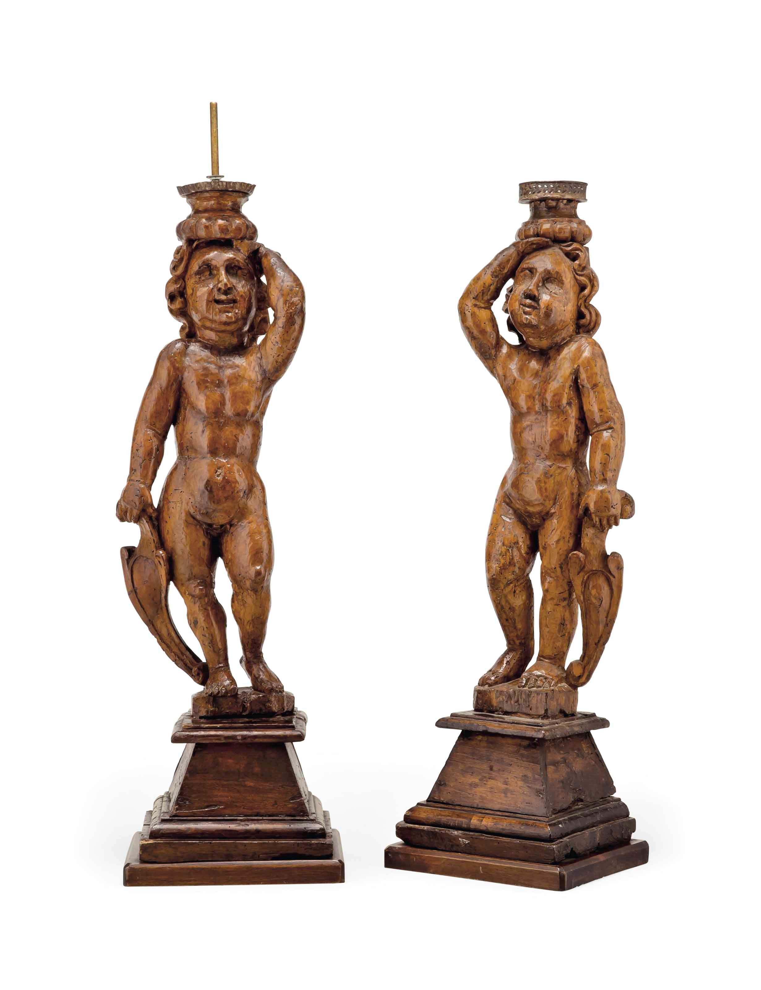 A PAIR OF SOUTH ITALIAN WALNUT FIGURAL CANDLESTICKS