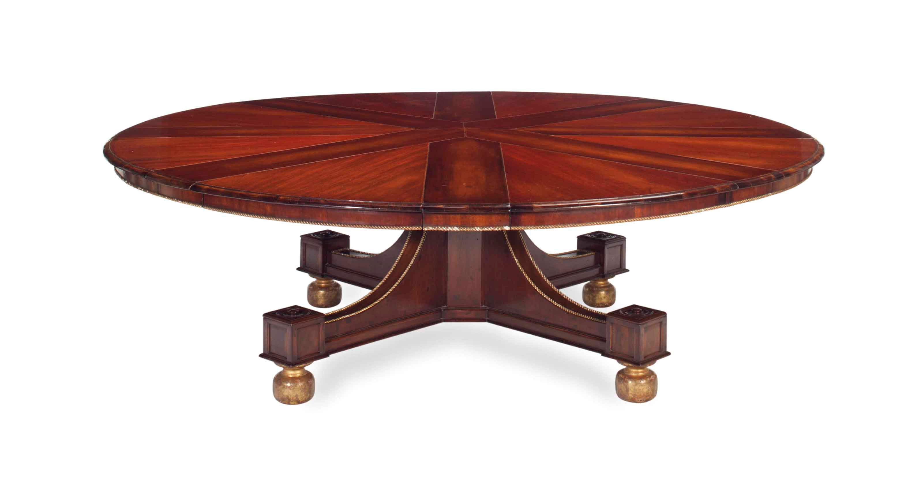 A REGENCY STYLE MAHOGANY AND PARCEL GILT CIRCULAR EXTENSION DINING TABLE,