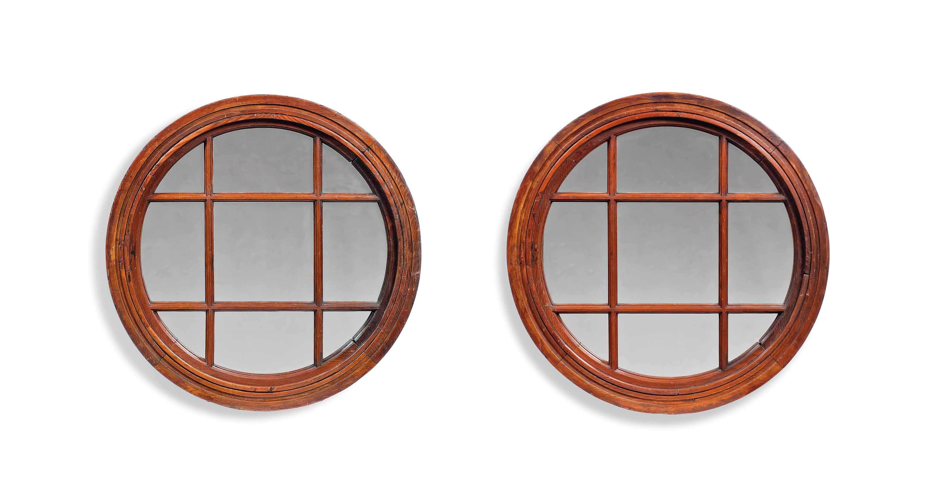 A PAIR OF VICTORIAN PINE CIRCULAR WINDOW FRAMES ADAPTED TO MIRRORS