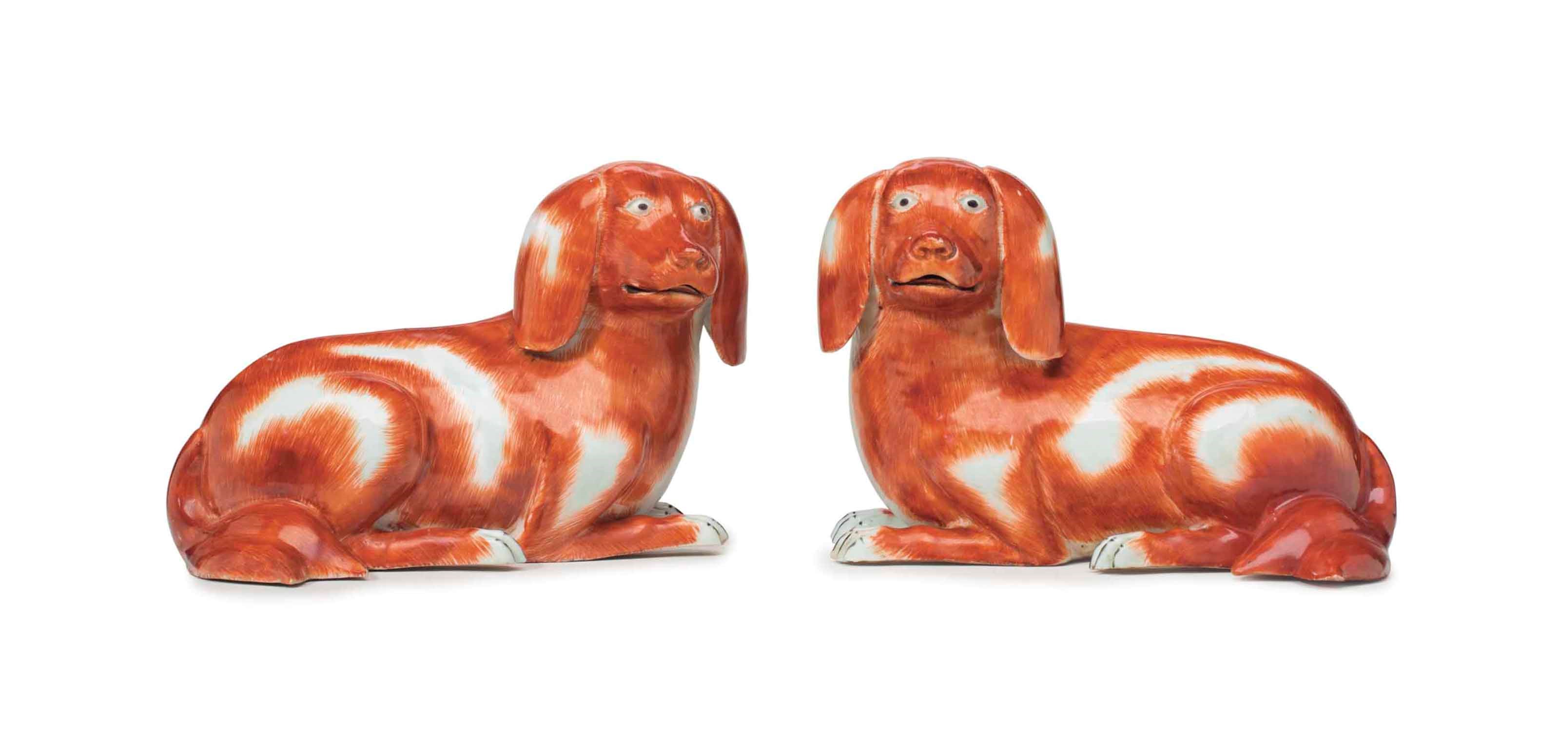 A PAIR OF RECUMBENT SPANIELS