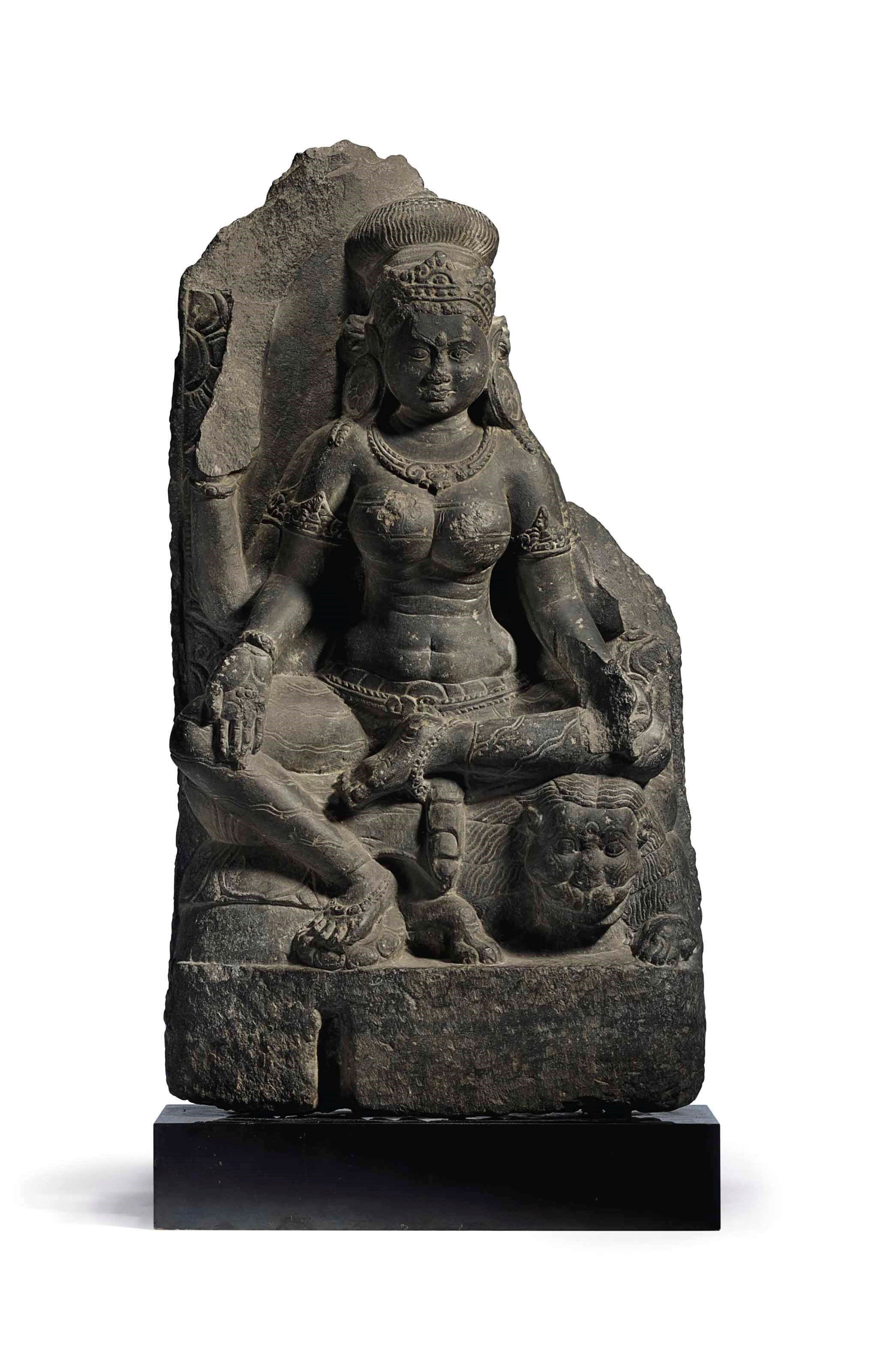 A BLACK STONE FIGURE OF DURGA SEATED ON A LION