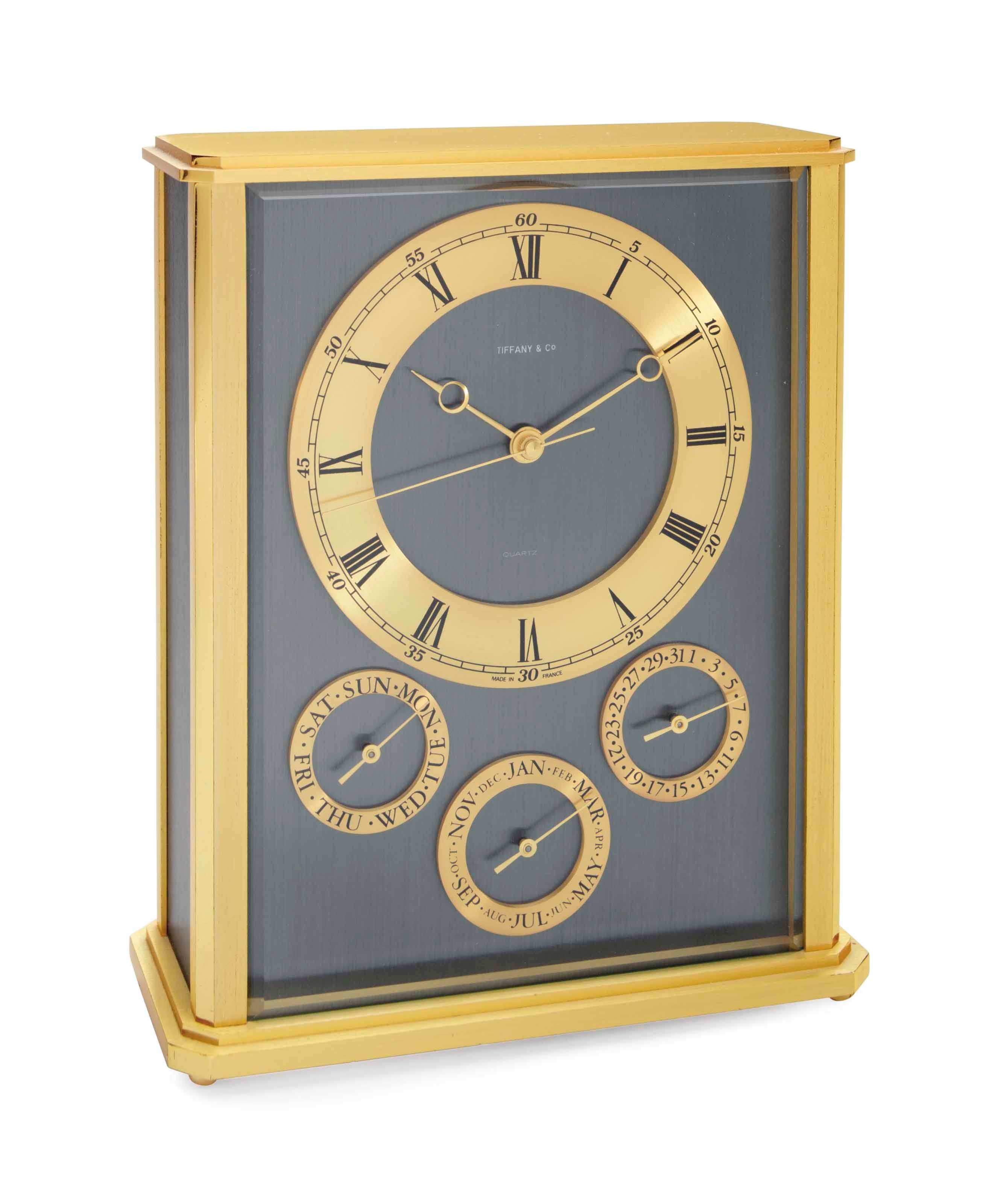 A FRENCH BRASS AND ENAMEL DAY, DATE, MONTH QUARTZ MANTEL CLOCK