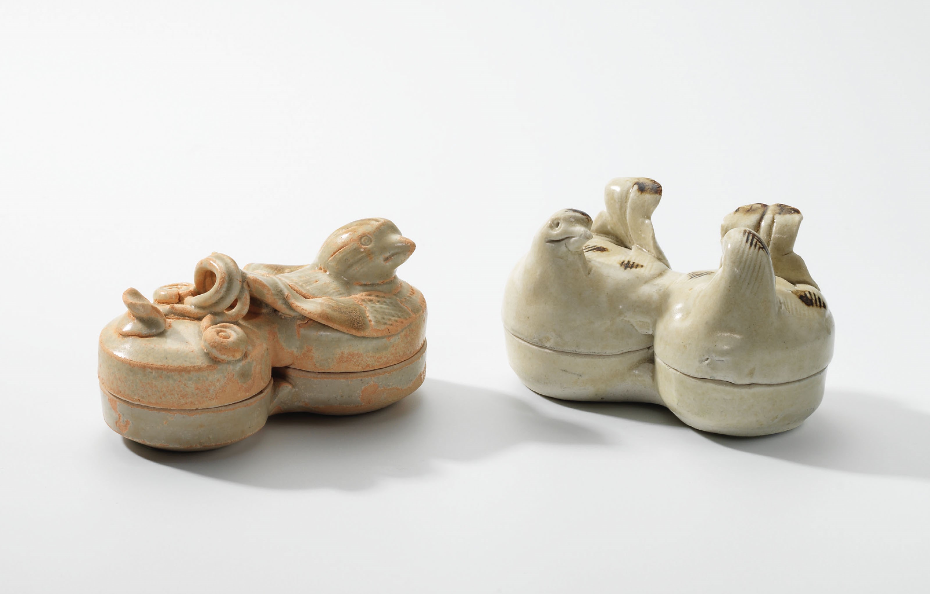 A QINGBAI IRON-SPOT ‘MANDARIN DUCKS’ CONJOINED BOX AND COVER AND A CELADON IRON-SPOT BIRD-FORM CONJOINED BOX AND COVER