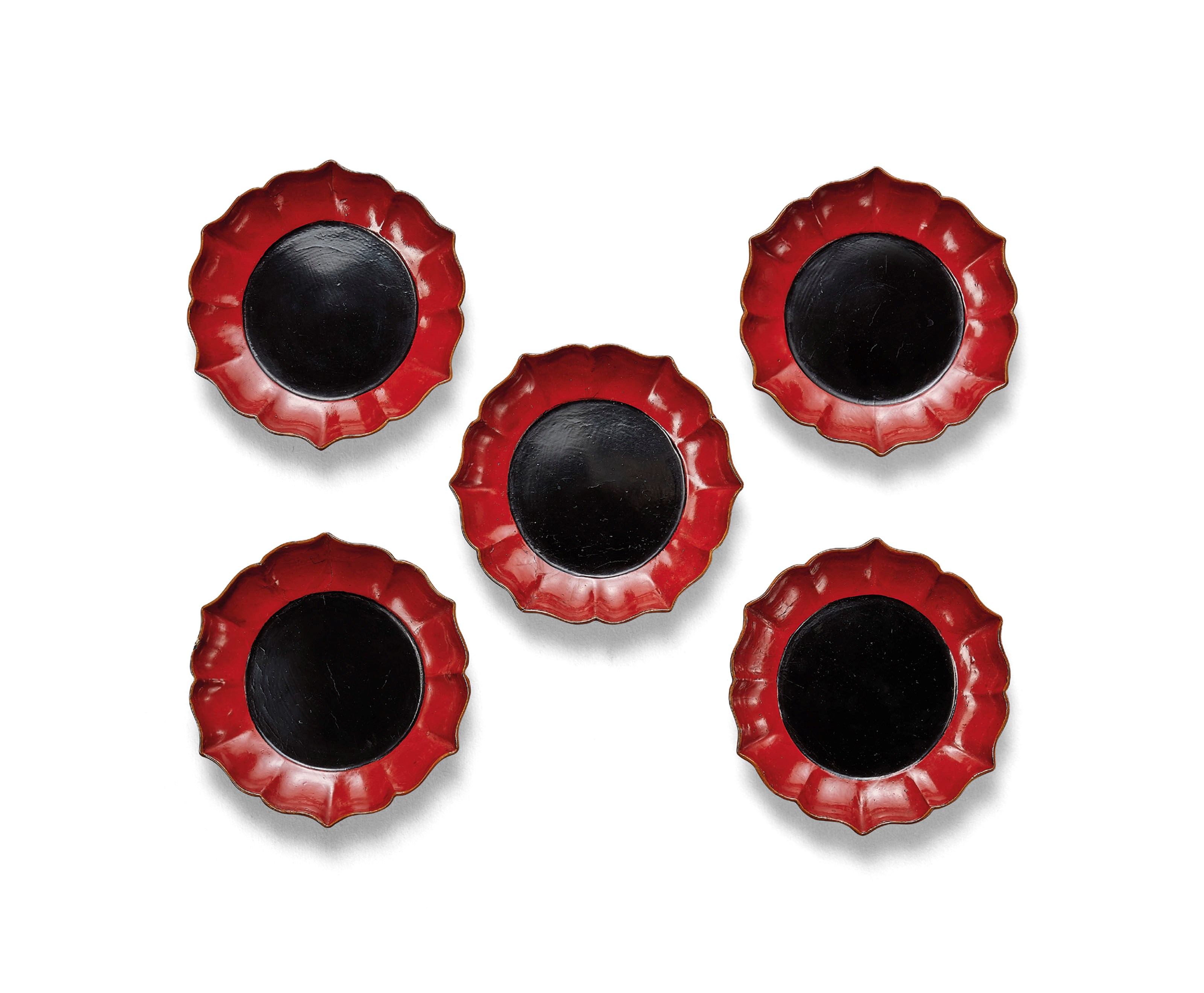 A RARE SET OF FIVE RED AND BLACK LACQUER FOLIATE-RIMMED DISHES