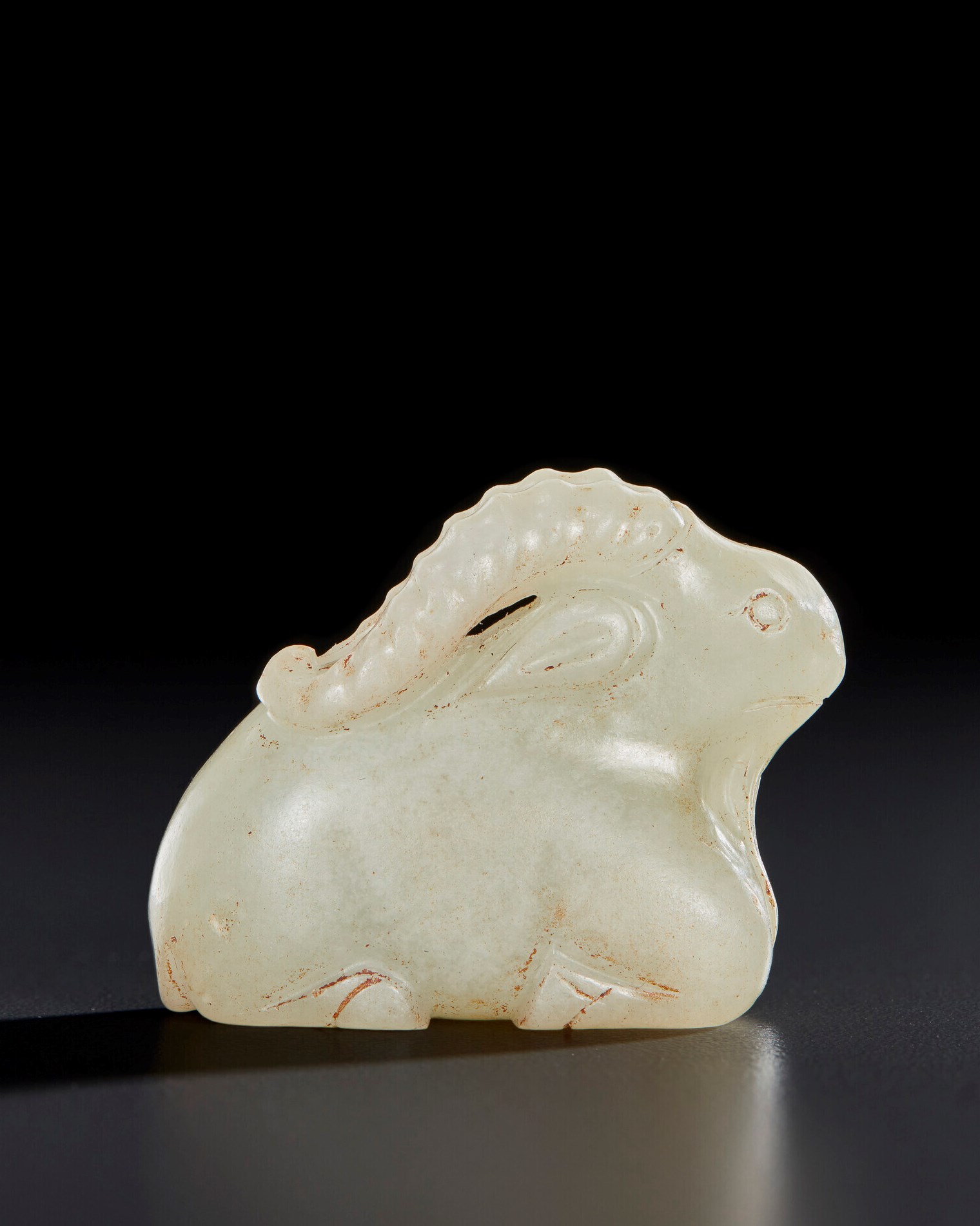 A RARE SMALL PALE GREENISH-WHITE JADE FIGURE OF A RECUMBENT RAM