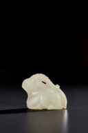 A RARE SMALL PALE GREENISH-WHITE JADE FIGURE OF A RECUMBENT RAM