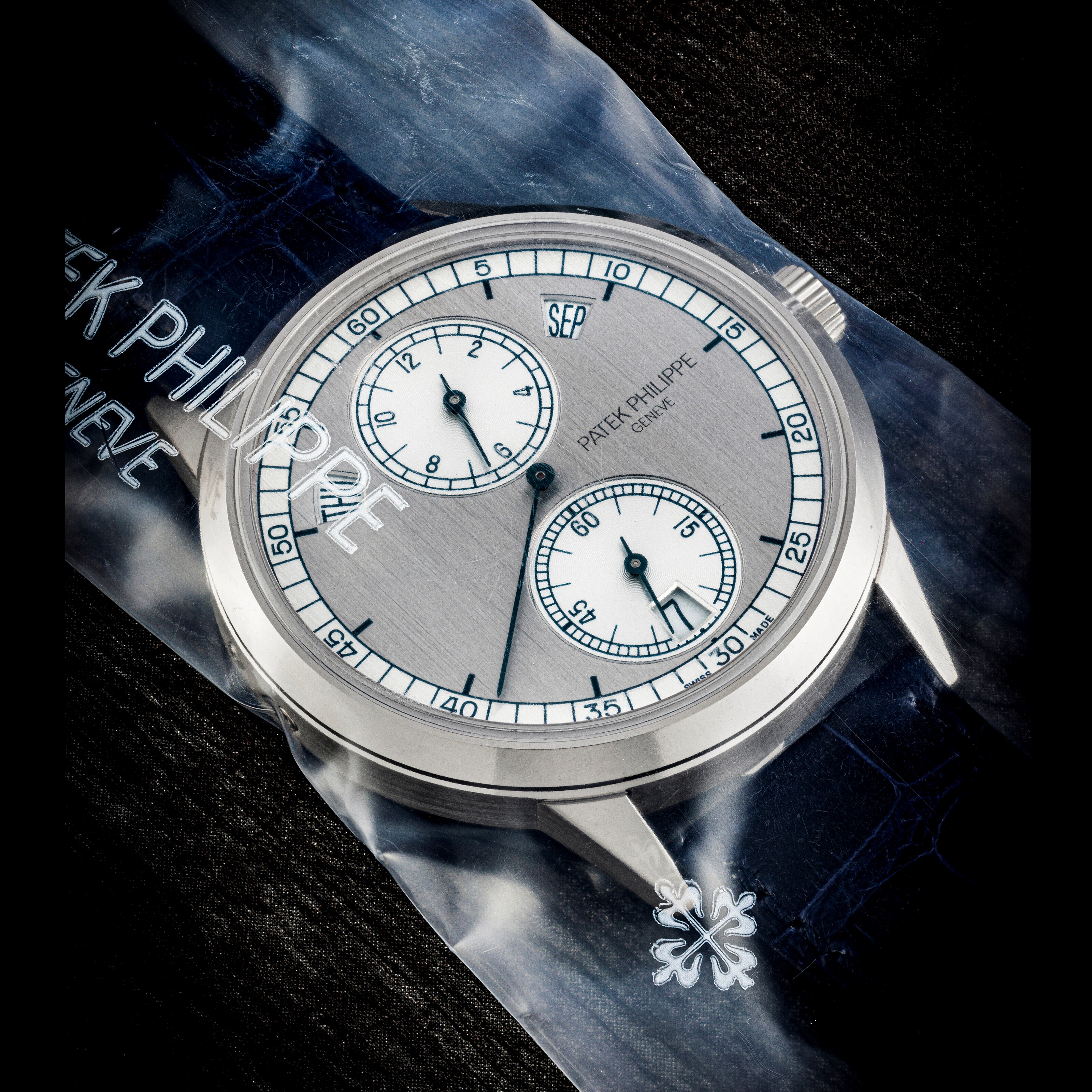 PATEK PHILIPPE. AN 18K WHITE GOLD AUTOMATIC ANNUAL CALENDAR WRISTWATCH WITH REGULATOR-STYLE DIAL, SINGLE SEALED