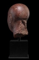 AN EGYPTIAN RED QUARTZITE HEAD OF A PRIEST