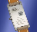 CARTIER. A SPECIAL ORDER RECTANGULAR CURVED PLATINUM WRISTWATCH WITH SALMON DIAL