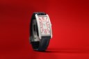 CARTIER. A UNIQUE AND EXTREMELY ATTRACTIVE PLATINUM LARGE RECTANGULAR CURVED WRISTWATCH WITH RED ARABIC NUMERAL DIAL