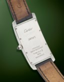 CARTIER. A UNIQUE AND EXTREMELY ATTRACTIVE PLATINUM LARGE RECTANGULAR CURVED WRISTWATCH WITH RED ARABIC NUMERAL DIAL
