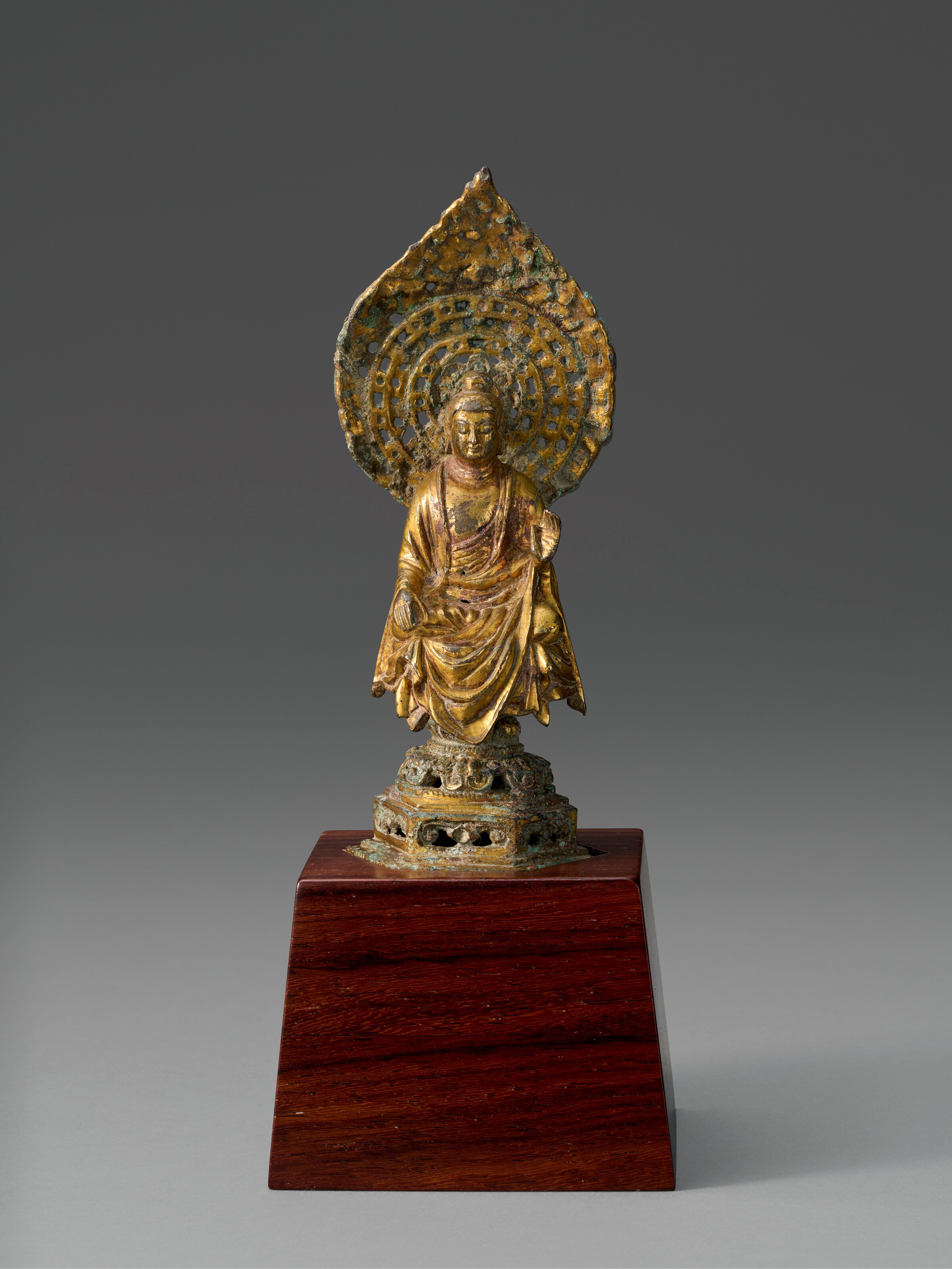 A SMALL GILT-BRONZE FIGURE OF A SEATED BUDDHA