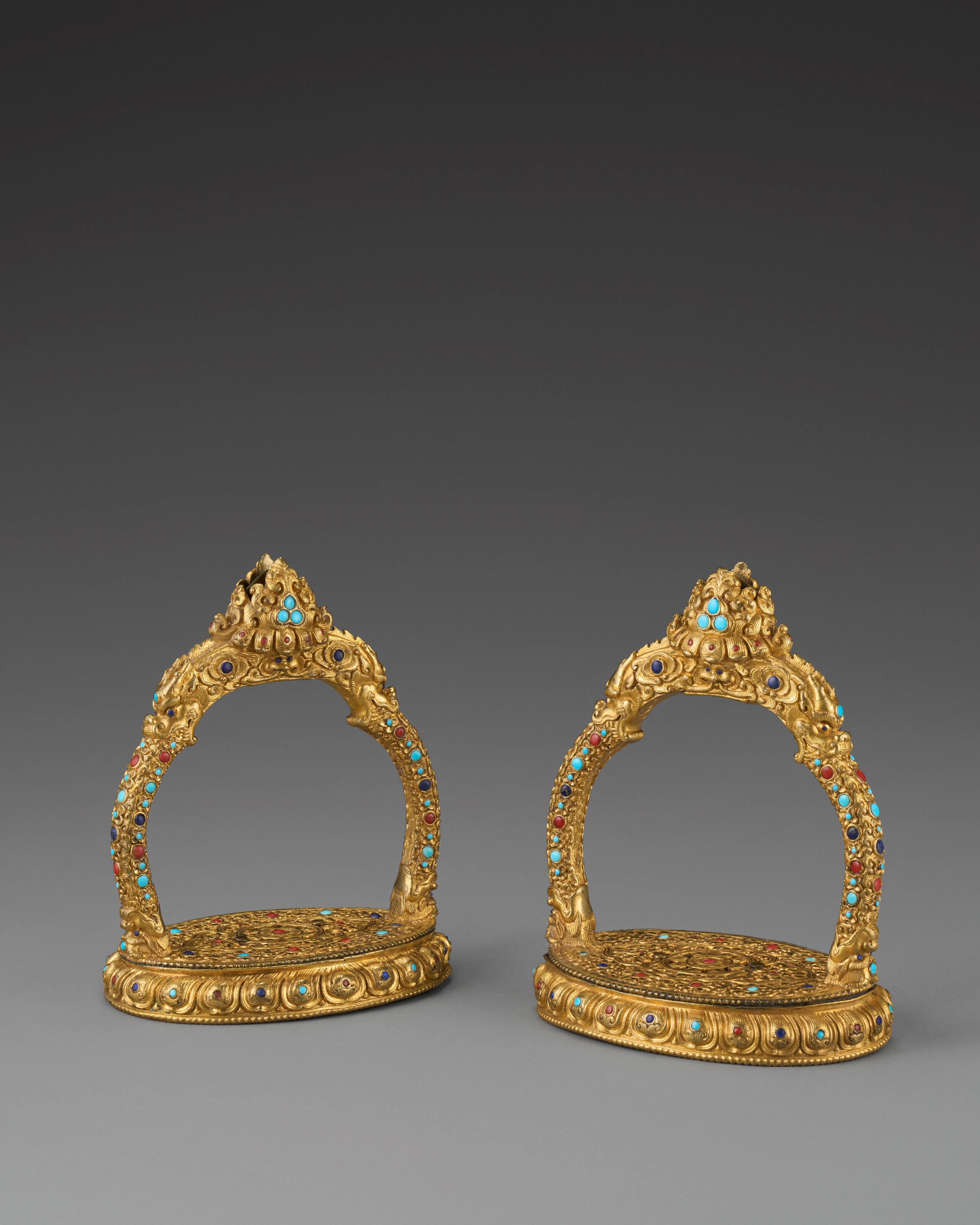 A VERY RARE AND EXCEPTIONAL PAIR OF EMBELLISHED GILT-BRONZE STIRRUPS
