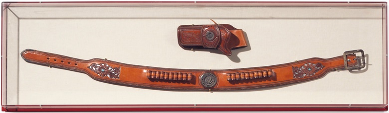 An American silver and turquoise-mounted leather gun belt and holster, by Galco International, Phoenix, Arizona. Last quarter 20th century. Each inset with a silver Seal of The President of the United States, within a lucite frame. 15¼ in (39 cm) high, 53½ in (136 cm) wide, overall. Formerly in The Family Residence, the White House, Washington D.C. Estimate $10,000-15,000.