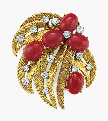A coral, diamond and gold brooch, by Ruser. Designed as openwork sculpted gold leaves, set with oval cabochon red corals and circular-cut diamonds, mounted in platinum and 18k-gold. Estimate $2,000-3,000. This lot will be offered in The Private Collection of President and Mrs. Ronald Reagan, 21-22 September at Christies in New York