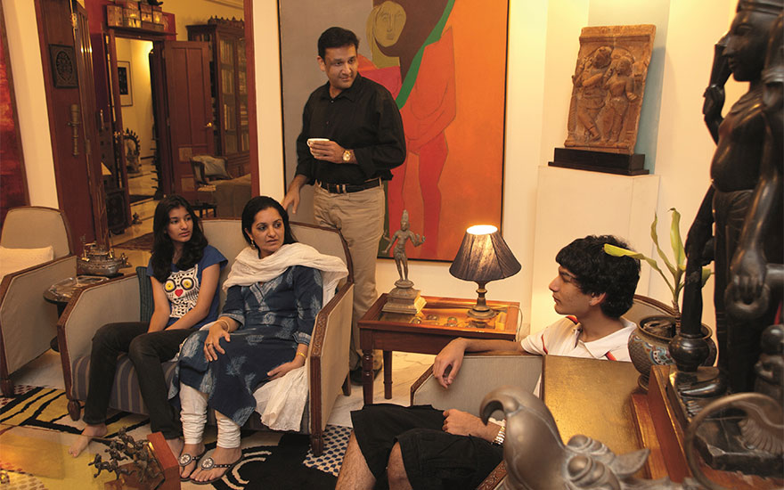 The Poddar family in their living room with Tyeb Mehta (1925-2009), Untitled (Diagonal), 1975, offered on 18 December in Mumbai. Photograph © Mahesh Bhat, image courtesy the Poddar family