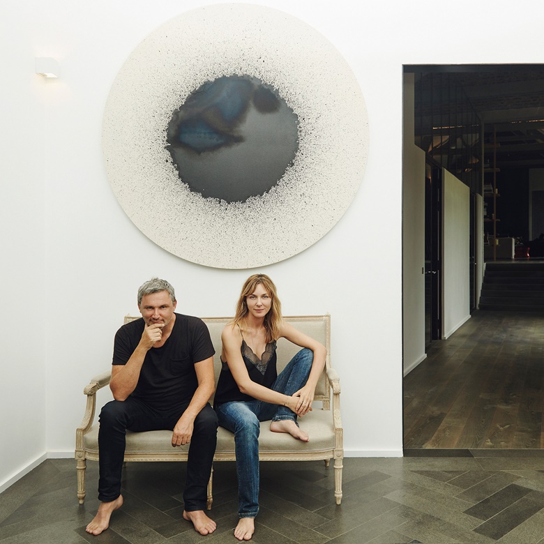Zadig & Voltaire founder Thierry Gillier and his wife Cecilia Bönström with (behind) Latifa Echakhch (b. 1974), Tambour 102, 2012. India ink on canvas. Diameter 68⅛ in (173 cm). Estimate $60,000-80,000. This work is offered in the Post-War and Contemporary Art Afternoon Session on 18 May at Christie’s in New York